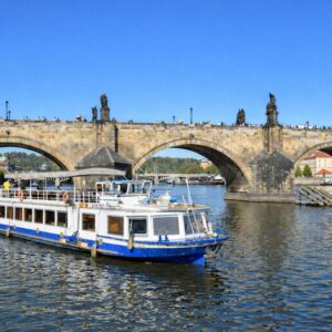 Velký parník při plavbě pod historickým kamenným mostem